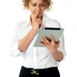 Businesswoman looking at tablet and thinking deep